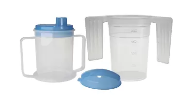 Black plastic straws next to a dual handled cup for elderly residents