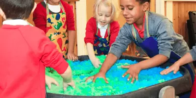 A group of children playing with slime in a tuff tray