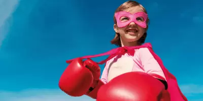 A girl dressed up in a super hero costume with boxing gloves