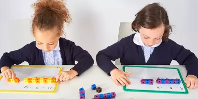 A boy and girl learning maths with cubes