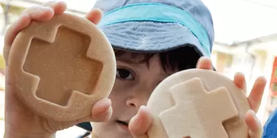 A boy holding tactile stones with matching patterns