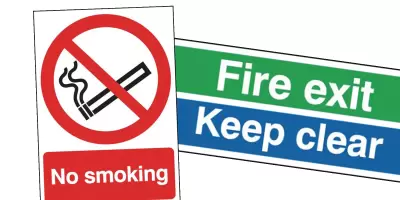 A no smoking sign and a fire exit keep clear sign